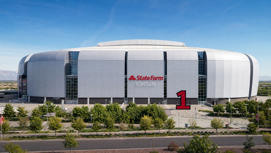 Exterior daytime view of State Farm Stadium in Glendale, Arizona, with a clear sky and trees in the foreground.